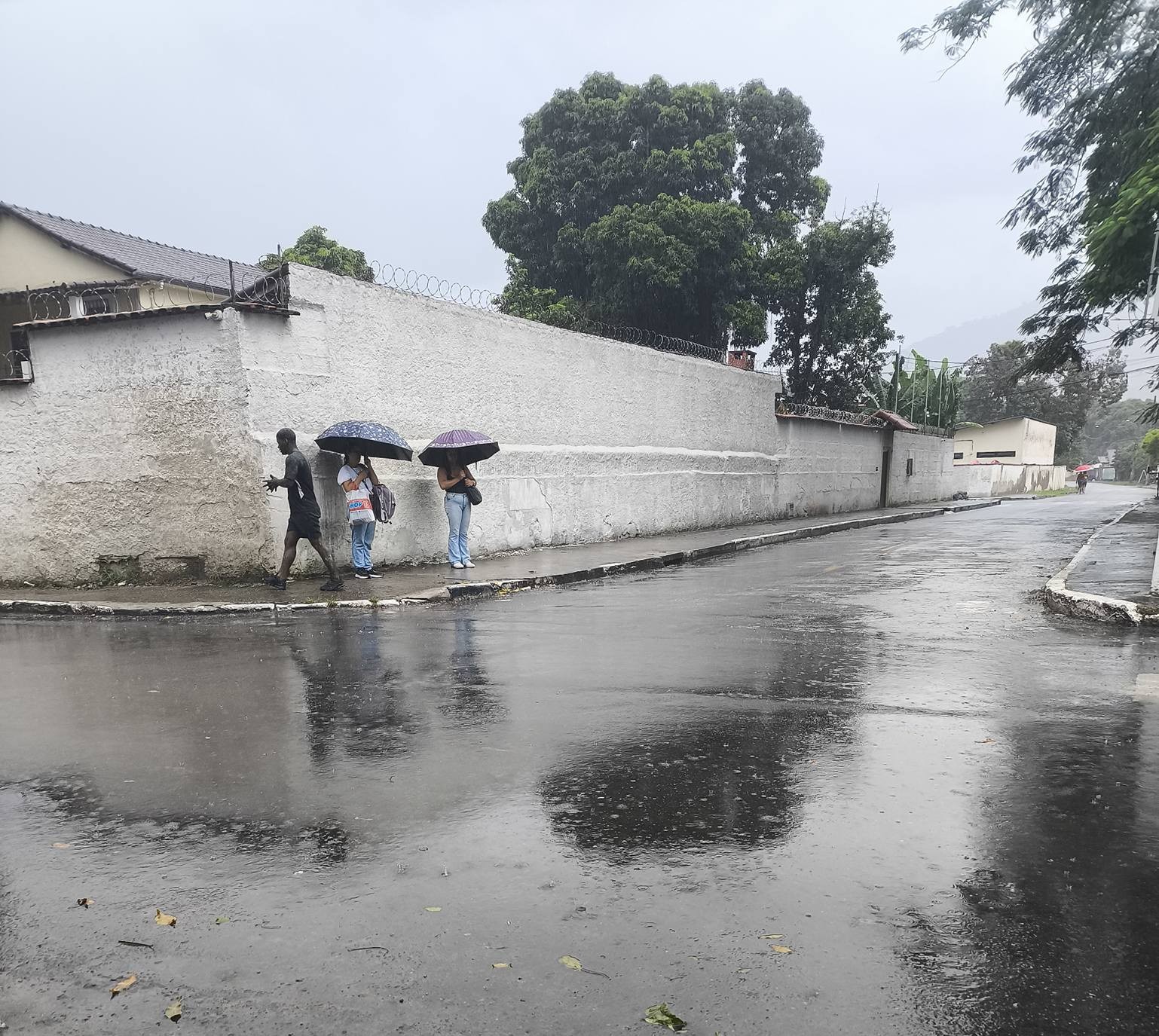 Passageiros aguardando ônibus em ponto sem cobertura na Quinta Mariana